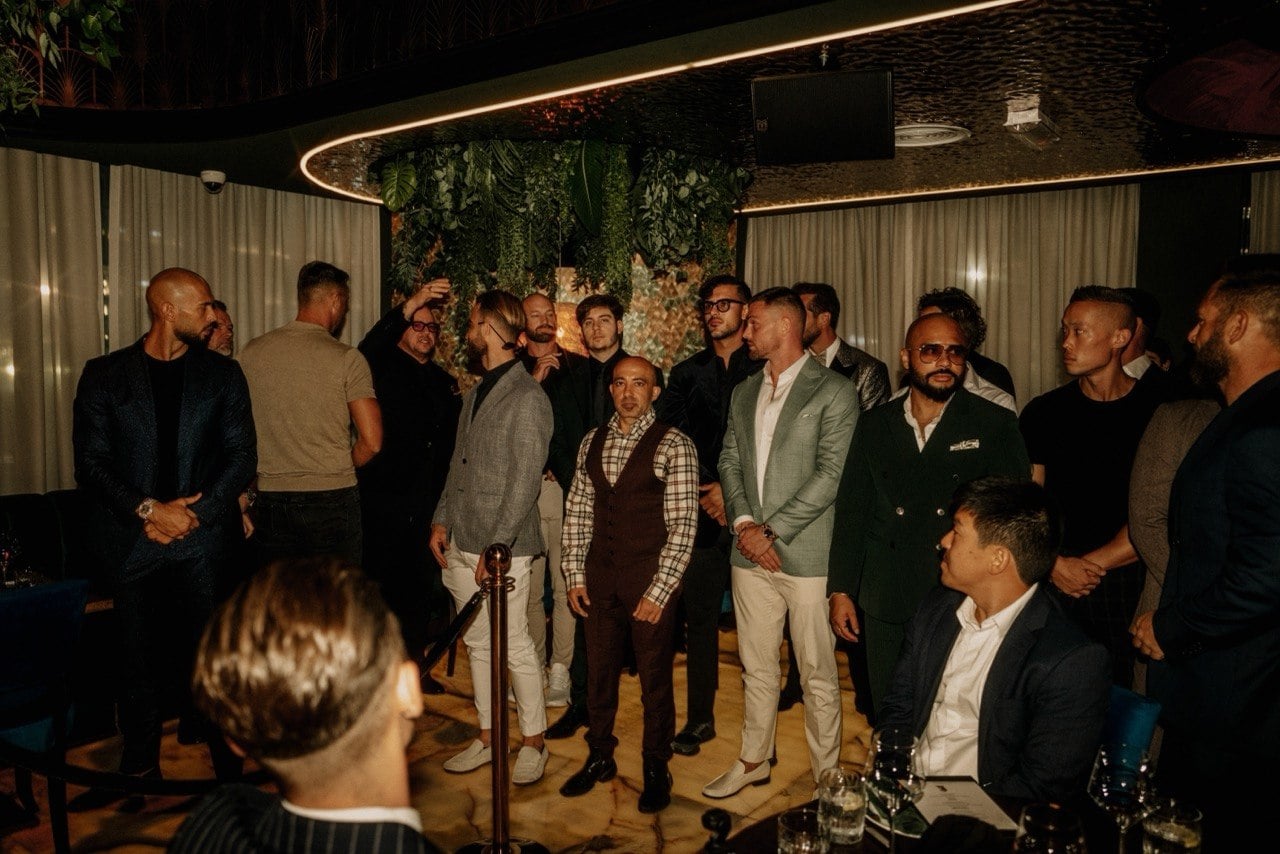 A room of men in evening tailoring gathered before dinner