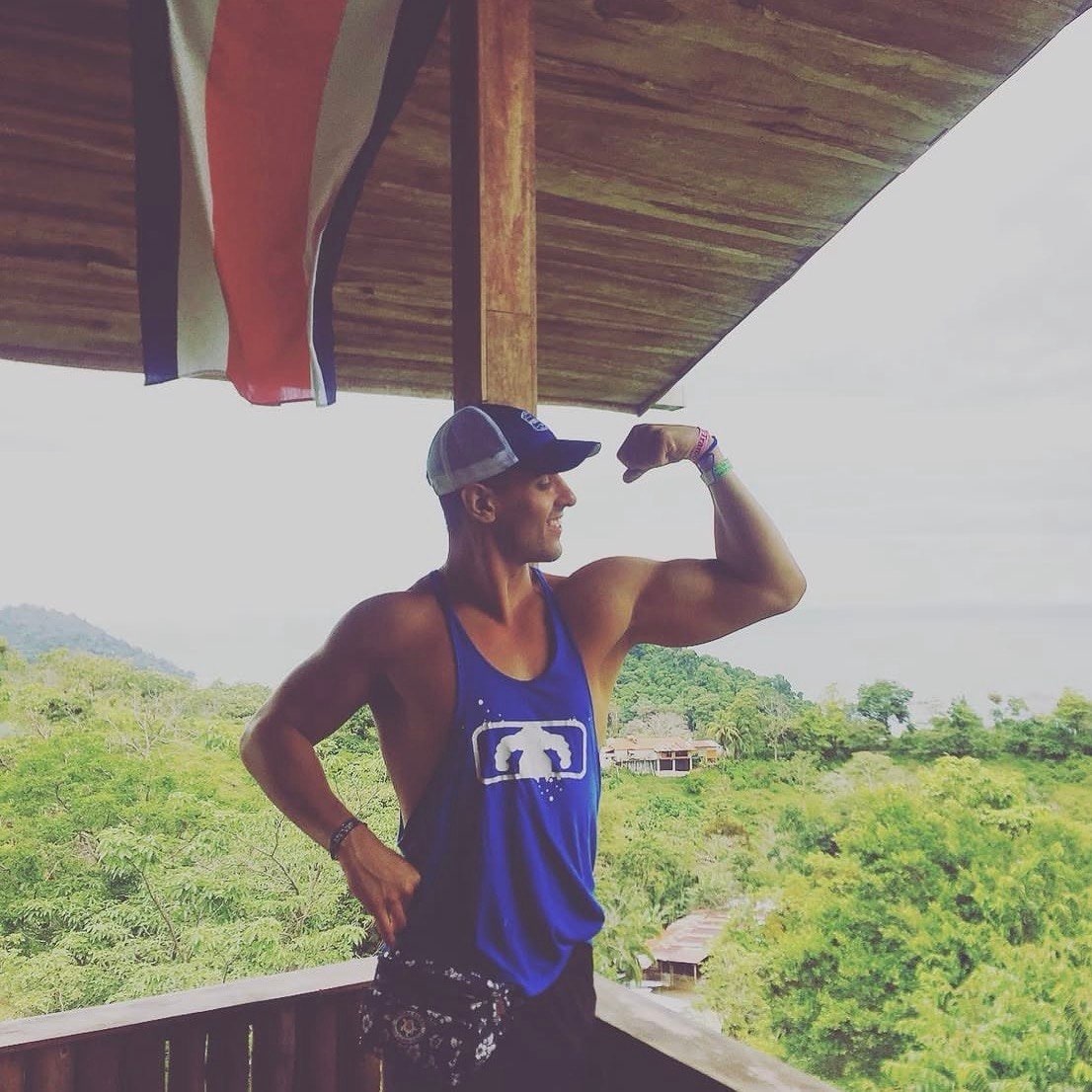 Ty flexing his arm on a balcony above the treeline