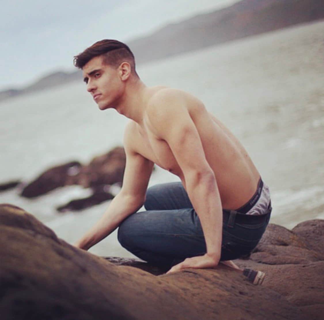 Ty crouched on the rocks at the edge of the water