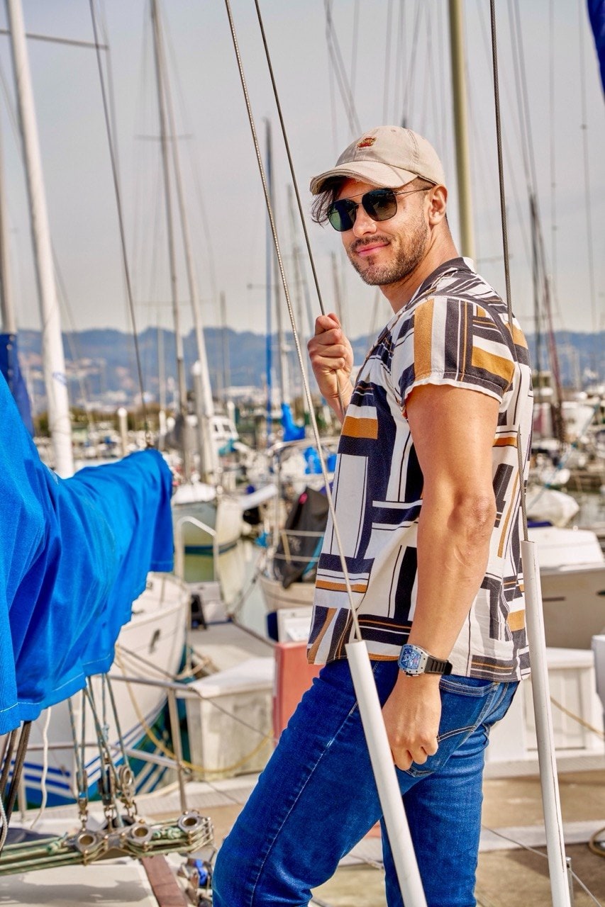 Ty on a dock beside moored sailboats, looking back over his shoulder