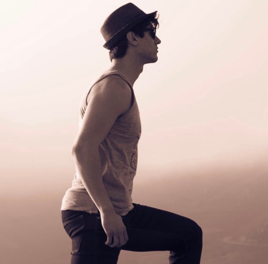 Ty in profile wearing a hat and sunglasses