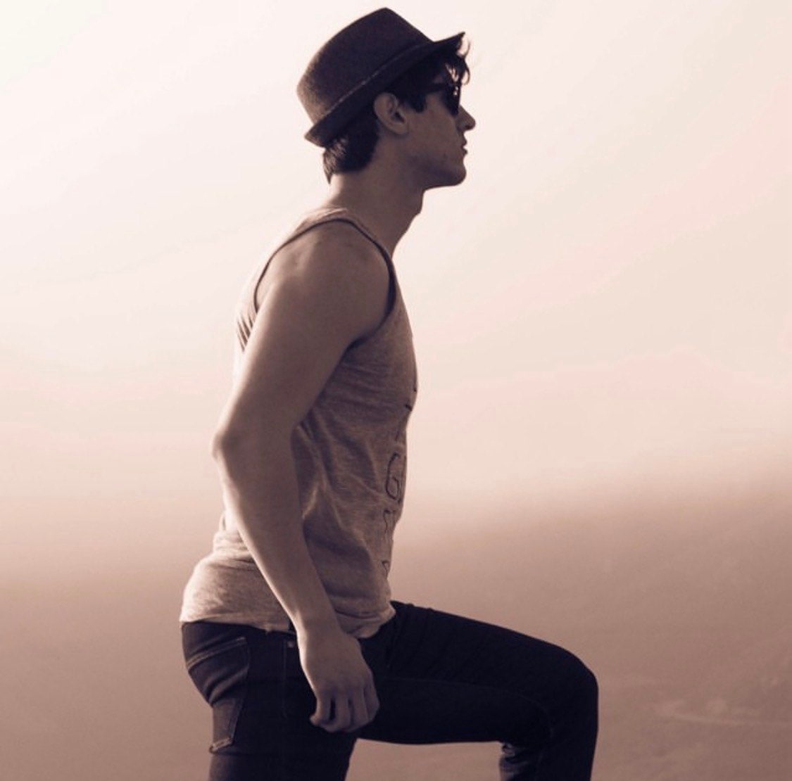 Ty in profile wearing a hat and sunglasses